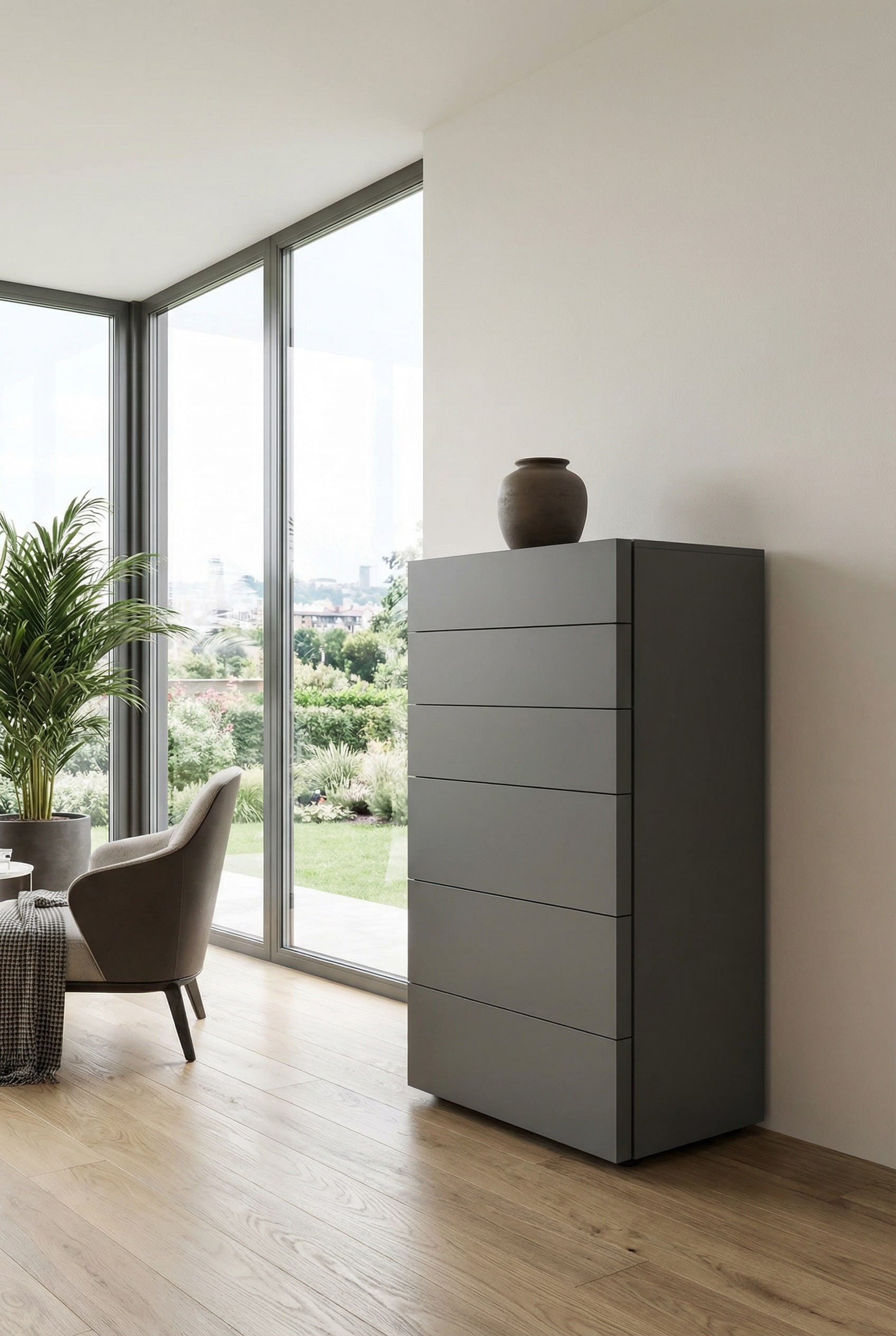 Eine moderne, grifffreie Hochkommode in edlem Dunkelgrau matt, die vor einer hellen Wand als minimalistisches und kontrastreiches Möbelstück inszeniert wird. Eine moderne, grifffreie Hochkommode in edlem Dunkelgrau matt, die vor einer hellen Wand als minimalistisches und kontrastreiches Möbelstück inszeniert wird.